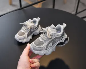 Close-up of kids' chunky sneaker featuring breathable mesh and grey leather textures