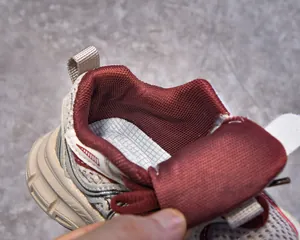 Detail of burgundy lining and breathable beige mesh upper on children's sneakers