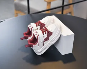 Détail de baskets enfant rouges et blanches avec fermeture scratch et semelle en gomme