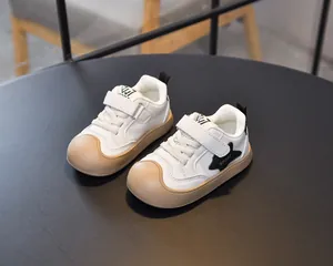 Detailed side view of kids white sneakers with reinforced khaki toe and star patch