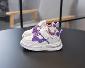 Détail de chaussures de course pour enfants blanches et violettes avec bande velcro et semelle