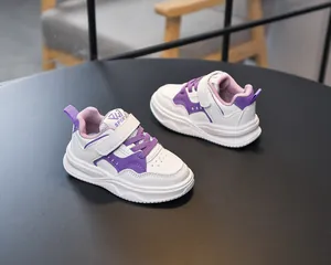 Détail de chaussures pour enfants avec sangles velcro violettes et semelle blanche robuste