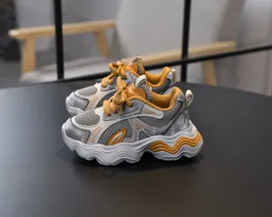 Close-up of girls breathable grey mesh sneakers with thick wavy soles and yellow laces