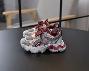Detail of girls breathable mesh sneakers featuring grey and burgundy patchwork rubber sole