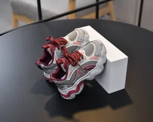 Detail view of breathable grey mesh upper with wine red overlays on kids sporty dad shoes