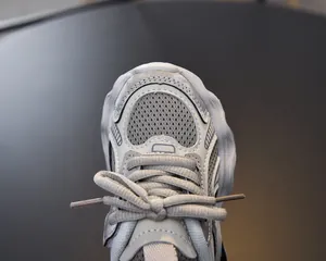 Close-up of girls gray chunky sneakers showing breathable mesh and leather textures