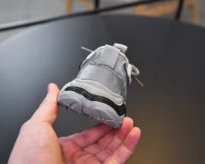 Detail view of children's chunky sneaker featuring thick non-slip rubber soles and pull tabs