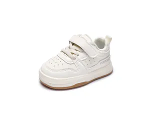 Detail of toddler sneakers with cream leather, velcro strap, and anti-slip rubber sole