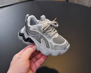 Detail view of children's grey mesh sneaker with unique wave-textured thick sole