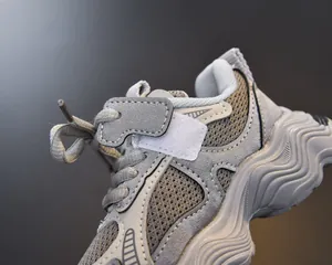 Detailed macro view of breathable mesh and wave-shaped thick sole on girl's chunky sneakers