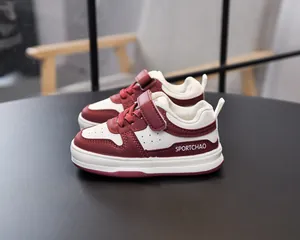 Side view of toddler sneakers featuring burgundy leather stitching and velcro straps
