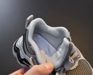Detail view of breathable grey mesh lining and padded collar for kids sports shoes
