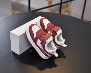 Detail view of red and white toddler sneakers with Velcro straps and rubber soles