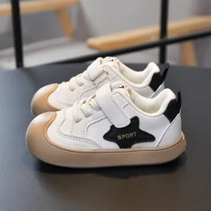 Kids minimalist beige sneakers with non-slip brown soles and black star patch details