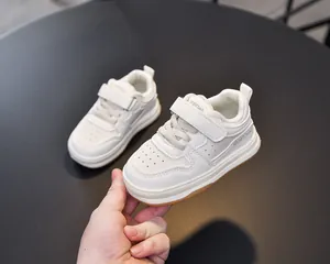Close-up of white toddler sneakers with breathable holes and convenient velcro strap