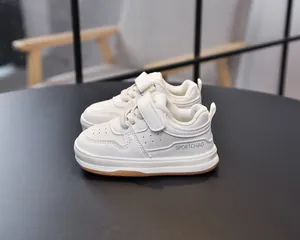 Detailed macro view of white toddler sneakers featuring breathable toe and velcro strap