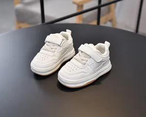 Detail of white toddler sneakers with Velcro straps and non-slip rubber outsoles