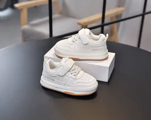 Detail of toddler white sneakers featuring breathable holes and velcro strap closure