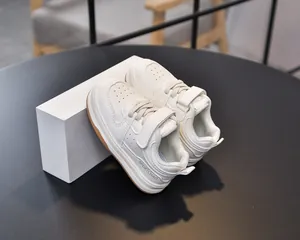 Detailed macro view of white toddler sneakers with breathable toe box and velcro straps