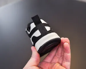 Close-up of the heel tab and stitching on black and white toddler walking sneakers
