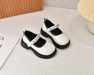 Vista detallada de zapatos Mary Jane marfil para niñas con pedrería y suela negra