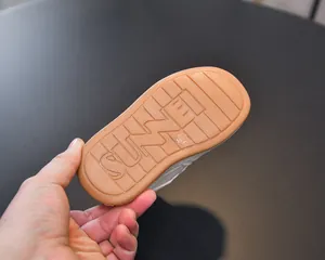 Detailed macro view of the non-slip rubber sole with grooved patterns on a white sneaker