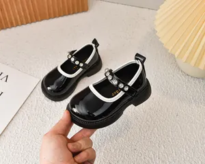 Detalle de merceditas en charol negro con hebilla de perlas y pedrería para niñas