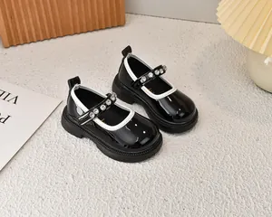 Detalle de zapatos Mary Jane de charol negro para niña con estrás y suela de goma gruesa