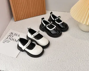 Detalle de zapatos Mary Jane en blanco y negro para niñas con correas de brillantes strass
