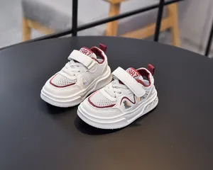 Detail of white children sports sandal showing mesh material and red 1987 embroidery