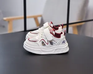 Close-up of white kids' sports sandals featuring red accents and non-slip soles