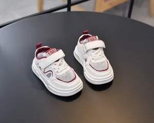 Detail of white and burgundy breathable mesh kids sandals with adjustable hook-and-loop straps