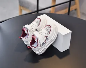 Detail of white and red kids sports sandals with hook-and-loop straps and floral sole