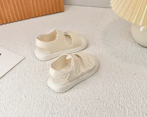 Vista dettagliata di sandali crema da bambina con chiusura a strappo su sfondo neutro
