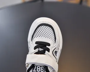 Close-up of kids sports sandals with breathable mesh and 1987 detail on the tongue