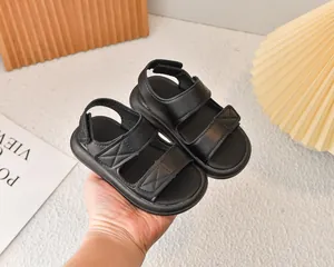Dettaglio di sandali neri per bambini in pelle con velcro e suola morbida antiscivolo