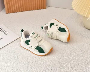 Detail of breathable mesh kids sneakers with green accents and non-slip rubber sole