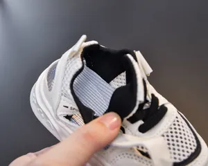 Detailed macro view of white kids sport sandals with mesh fabric and blue lining