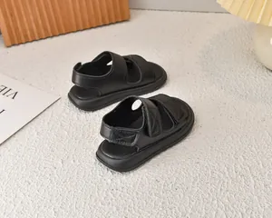 Dettaglio macro di sandali in pelle nera trapuntata con velcro e suole spesse