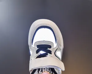 Detail view of children sports shoes showing glowing leather and honeycomb mesh with 1987 tag