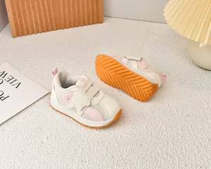 Close-up of baby sneakers with breathable mesh, orange non-slip sole and Velcro strap