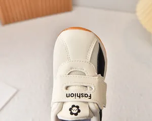 Detail of breathable mesh kids sneaker with hook-and-loop closure and cartoon flower logo