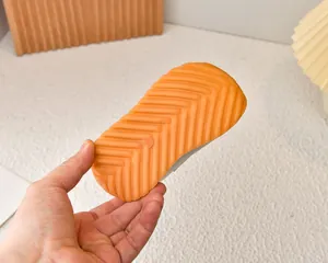 Detailed view of flexible orange rubber sole with anti-slip herringbone pattern for kids shoes