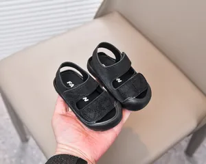 Close-up of black baby sandals with double hook and loop straps and anti-collision toe cap