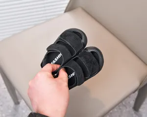 Detail view of toddler sandals featuring dual hook-and-loop straps and non-slip rubber soles