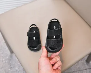 Detail view of black toddler sandals featuring double hook-and-loop straps and non-slip sole