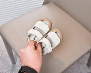 Detail of infant sandals featuring dual velcro straps and protective rubber toe cap
