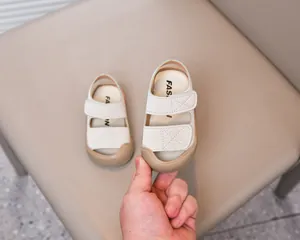 Detail of beige toddler sandals with protective rubber toe cap and velcro straps