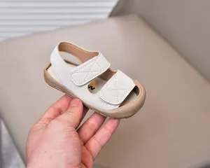 Detail of baby summer sandals featuring cream leather straps and soft rubber sole