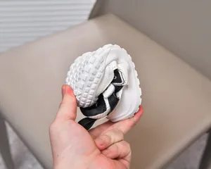 Dettaglio del sandalo flessibile per bambini bianco e nero con suola morbida antiscivolo